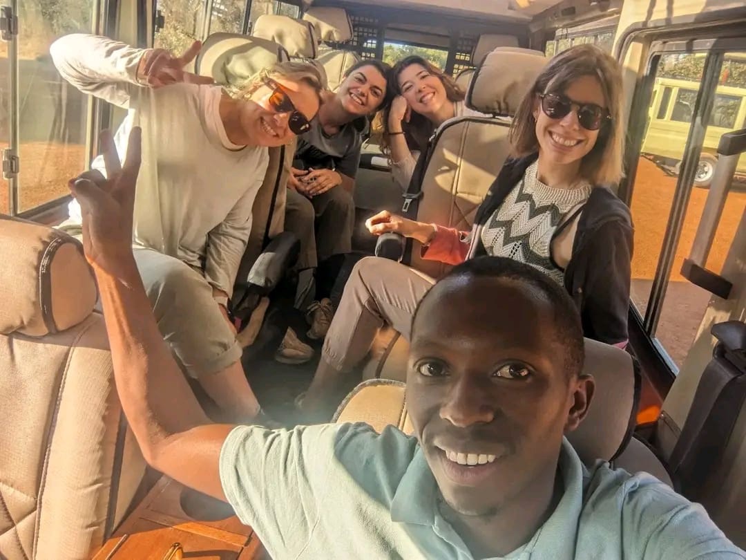 Guide and guests smiling inside the safari vehicle on the Akagera group safari from Kigali