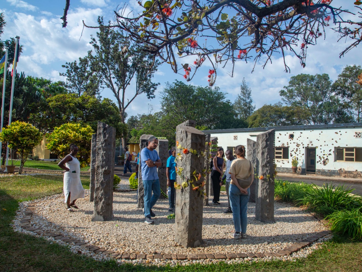 Tour guests among the ten stone pillars of the Belgian Peacekeepers Memorial at Camp Kigali